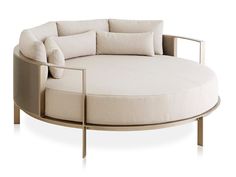 a round couch with pillows on it and a metal frame around the backrests