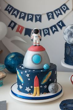 a space themed birthday cake with an astronaut on top