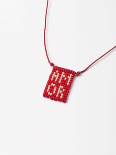 a red beaded necklace with the word love spelled in white letters on an orange string