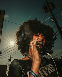 a woman with an afro is talking on her cell phone