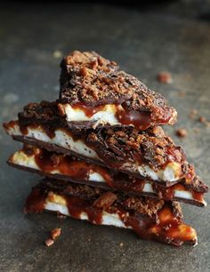 three pieces of chocolate and marshmallow dessert stacked on top of each other