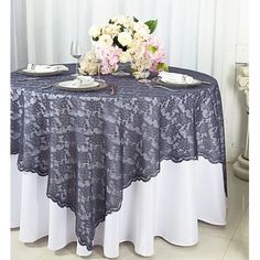 the table is covered with black lace and flowers