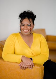 a woman sitting on top of a yellow couch