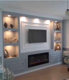 a living room filled with furniture and a flat screen tv mounted on a wall above a fire place