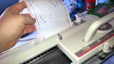 someone is using a sewing machine to sew on some paper and thread it together