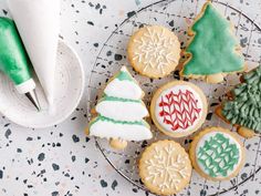 decorated christmas cookies on a wire rack next to a paper towel and green marker pen