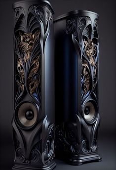 two black speakers with intricate designs on the front and back sides, side by side