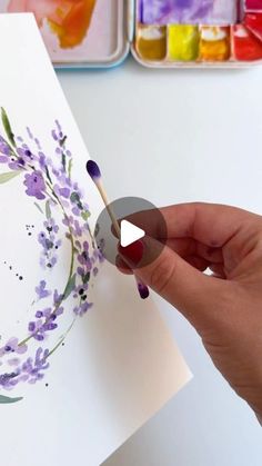 someone is painting flowers with watercolors on paper