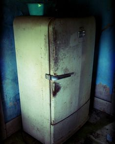 an old refrigerator sitting in the corner of a room