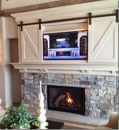 a living room with a fire place and tv above the fireplace