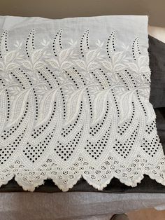 a white lace doily on top of a black cushion with a pair of shoes next to it