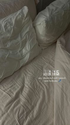 an unmade bed with white pillows on top of it and the words 11 15 above them