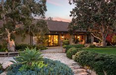 a house with landscaping and trees in the front yard