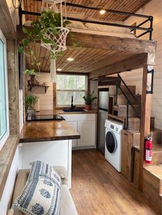 a small kitchen with wood flooring and white walls, along with a wooden ceiling