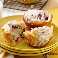 two muffins with white icing on a yellow plate