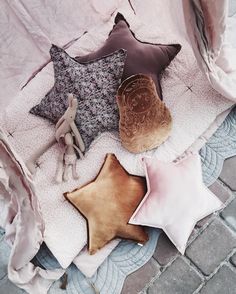 five star shaped cushions on a blanket with one stuffed animal and the other plush toy