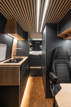 the interior of an rv with wood paneling on the ceiling and black leather seats