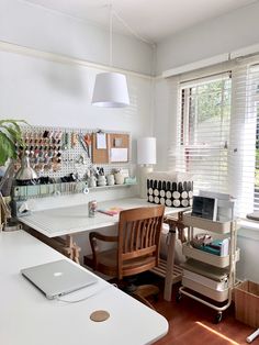 a desk with a laptop computer on it in a room filled with furniture and decor