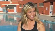 a woman standing in front of a swimming pool