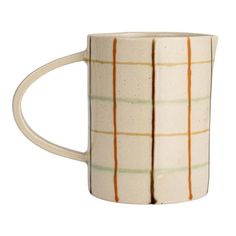 a coffee mug with orange and green lines on the outside of it, sitting in front of a white background