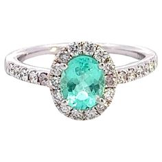 Elevate your jewelry collection with this stunning Paraiba tourmaline ring, a true testament to elegance and sophistication. Crafted in lustrous 14k white gold, this ring features a vibrant oval Paraiba tourmaline gemstone measuring 7x5mm, with a mesmerizing weight of 0.89 carats. Known for its rare and captivating blue-green hue, Paraiba tourmaline is a gemstone coveted by collectors and connoisseurs alike. Surrounding the exquisite Paraiba tourmaline are 0.54 carats of dazzling diamonds, addin Paraiba Tourmaline Ring, Paraiba Tourmaline, Rare Gemstones, Tourmaline Ring, Unique Gemstones, Tourmaline Gemstone, Cocktail Rings, Ring Verlobung, Tourmaline