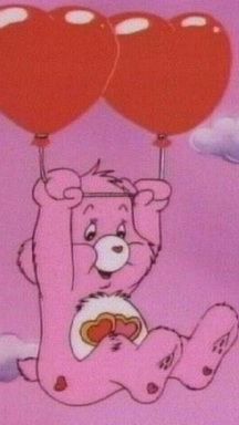 a pink bear holding two red balloons in the air