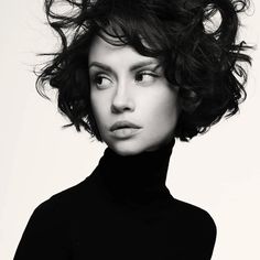 a black and white photo of a woman with curly hair