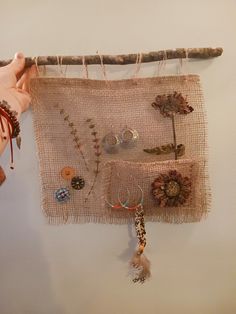 a wall hanging made out of burlap with beads and other items on it