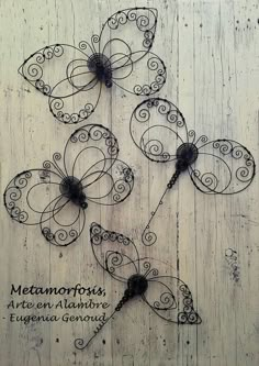 four metal butterflies with the words metatrosis written on them and attached to wood planks