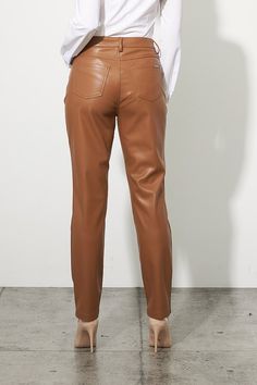 This pant features a faux leather construction, ultra-soft to the touch. Joseph Ribkoff's classic five-pocket design offers the utmost versatility for a chic finish. Perfect for the office or a night out on the town, this style effortlessly completes any outfit. Color - Nutmeg. Back pockets. Front pockets. Zipper and button closure. Belt loops. Joseph Ribkoff silver tag. Straight leg design. Fabric- 55% Polyurethane. 45% Polyester. Sleek Bottoms With Five Pockets For Fall, Casual Leather Pants With Five Pockets For Fall, Sleek Leather Bottoms For Fall, High Waist Leather Bottoms With Faux Front Pockets, Trendy Leather Bottoms With Five Pockets, Sleek Mid-rise Leather Pants For Fall, Fitted Faux Leather Classic Bottoms, Classic Fitted Faux Leather Bottoms, Chic Brown Bottoms With Five Pockets