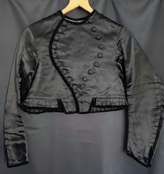 Satin Black Vintage Folklore Jacket. ▪︎●▪︎ The jacket originates from Germany and is part of a stunning traditional folklore costume. The outer fabric is in a rich black satin with velvet on the rim. Also decorated with stunning handcrafted buttons. The fit is in the style of a short bolero. A great look with high waisted jeans or skirts.   From ca. 1940s. ☆ ☆ ☆ handrafted traditional one of a kind ☆ A size S minus (small UK 8/European 36). Bust 45 cm/17.71" Shoulders 36 cm/14.17'' Length approx. 38 cm/14.96'' Necklace 16 cm/6.29" Arms 57 cm/22.44" -armhole 19 cm/7.48" -arm width15cm/5.90" -cuff 11 cm/4.33" ♡Super Rare Collectable♡ Folklore Costume, Satin Noir, High Waisted Jeans, Black Vintage, Inspiration Mode, Black Satin, High Waist Jeans, Bathing Beauties, Jackets & Coats