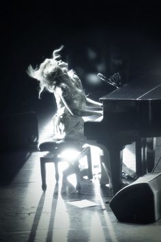 a woman is playing the piano in black and white