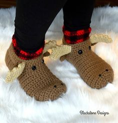 the legs and feet of a person wearing crocheted moose slippers