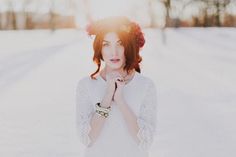 a woman standing in the snow with her hands on her chest