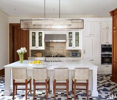 a large kitchen with white cabinets and black and white checkered flooring on the walls