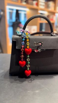 This retro colorful heart bag charm is very versatile and aesthetically pleasing. It can be paired with various styles of bags. I selected the latest glossy plump heart beads, which have excellent saturation and a beautiful true red color. The charm is complemented by a variety of colorful natural high-quality stones and finely crafted, highly transparent acrylic beads as the chain. Its texture feels very premium, and it looks stunning in person. I really love it and wanted to share it with ever Luxury Heart-shaped Bags For Gifts, Heart-shaped Handmade Bags For Gifts, Handmade Heart-shaped Gift Bag, Heart-shaped Multicolor Bag For Gift, Heart-shaped Multicolor Gift Bag, Heart-shaped Beaded Bag For Gifts, Heart-shaped Beaded Bag As Gift, Beaded Bag Strap, Heart Beaded Bag