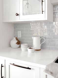 a white kitchen counter with dishes on it