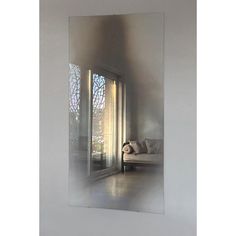 the reflection of a couch and window in a glass door frame on a white wall