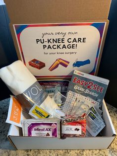 an open box filled with various items on top of a marble countertop next to a sign that reads, pu - knee care package for your knee surgery