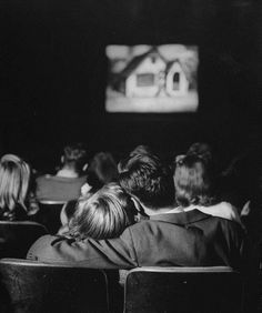 several people sitting in chairs watching something on the screen