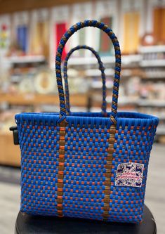 Tough, cute, and eco-friendly, these bags are great for everyday use! Handwoven from recycled plastic, every pattern is unique. Some are even accompanied by a vibrant, handmade pom-pom/heart ornament! Measurements are formatted: L x W x H in inches. Handmade in Oaxaca, México. Blue Handwoven Bag As A Gift, Artisan Blue Rectangular Bag, Handwoven Blue Square Bag, Blue Handwoven Square Bag, Artisan Blue Bag For Gift, Blue Square Handwoven Bag, Eco-friendly Blue Bag From Recycled Materials, Eco-friendly Blue Bag Made Of Recycled Materials, Eco-friendly Blue Bags Made From Recycled Materials