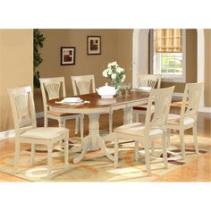 a dining room table with white chairs and a rug on the floor in front of it