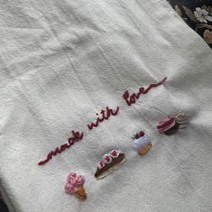 embroidered tea towel with words made with love and cupcakes on it sitting on a table