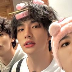 three young men with hair clips on their head and one wearing a pink teddy bear hat