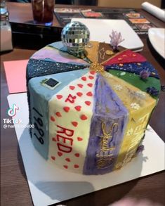 a cake decorated with many different colors and designs on it's side sitting on top of a table