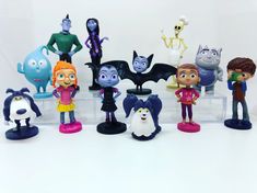 various toy figurines are displayed on a white surface, including characters from the animated series