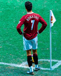 a man standing on top of a soccer field next to a white flag with the number seven