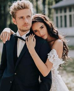 a man in a tuxedo hugging a woman