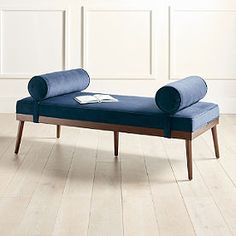 a blue bench sitting on top of a hard wood floor next to a white wall