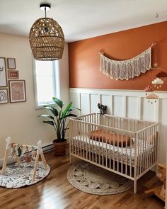 a baby's room with an orange wall and white crib in the corner